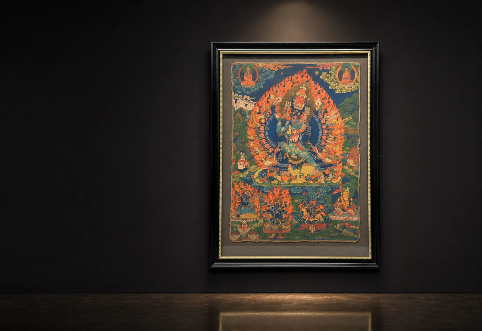 Thangka held beneath a gallery light in a private viewing room